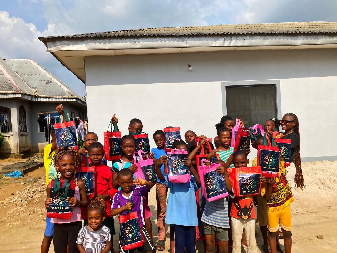 Group of Nigerian children proudly holding Spread Light gift bags